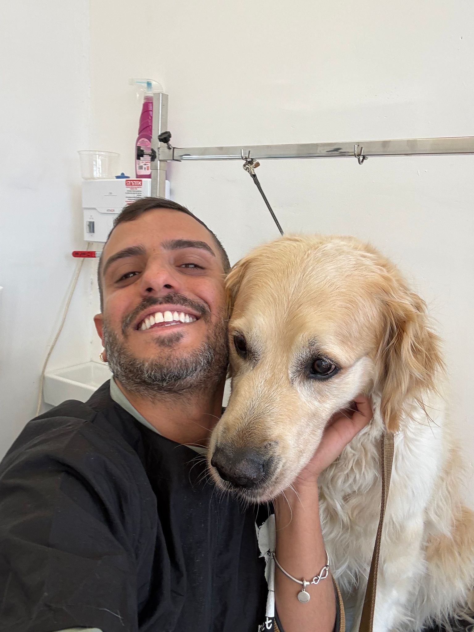 בחור צעיר מחייך ומחזיק כלב