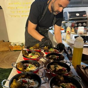 סער עומר ליד שולחן ומארגן מנות אוכל