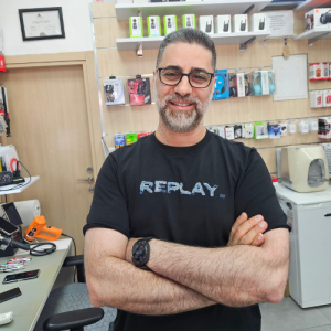 ניר עומד בשילוב ידיים ומחייך למצלמה